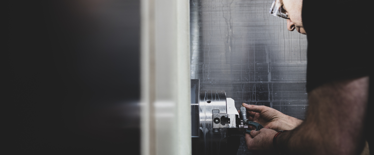 Machinist measuring parts in a CNC machine